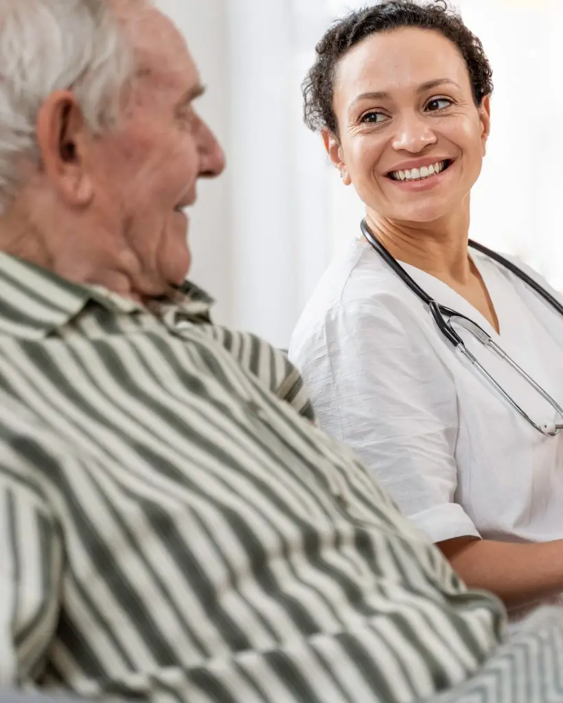 Infirmière à domicile discutant avec son patient âgé